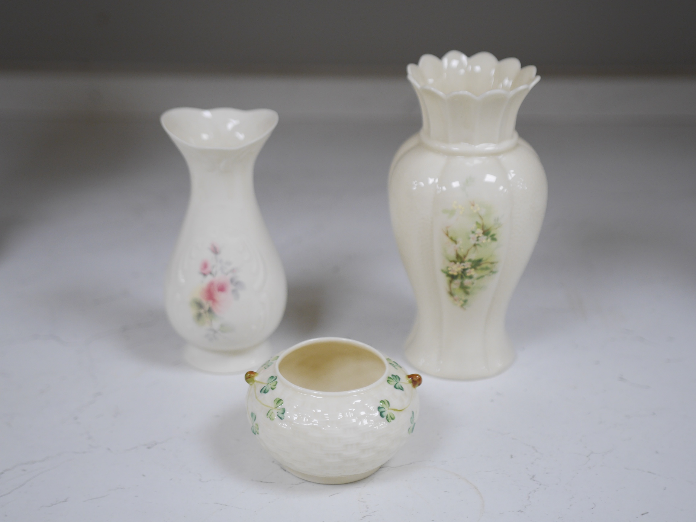 A Belleek serving plate, milk jug and two bowls and three Donegal vases, tallest item 25cm high. Condition - good